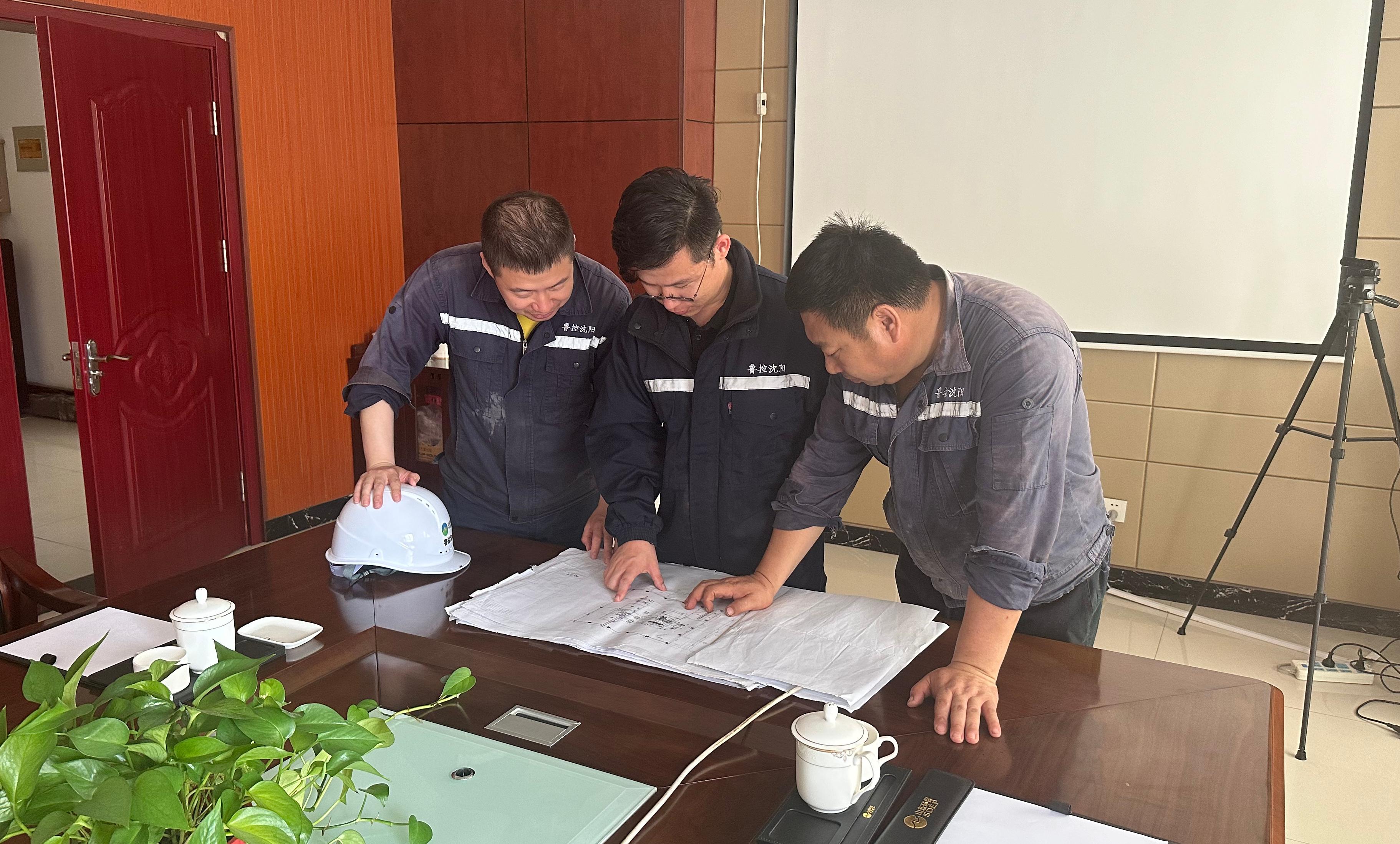 孫茂(中間)與同事研究篩分機調整方案.jpg